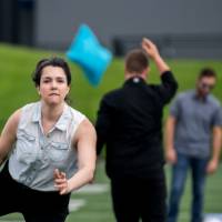 Women throwing a cornhole bag with sheer determination on her face
